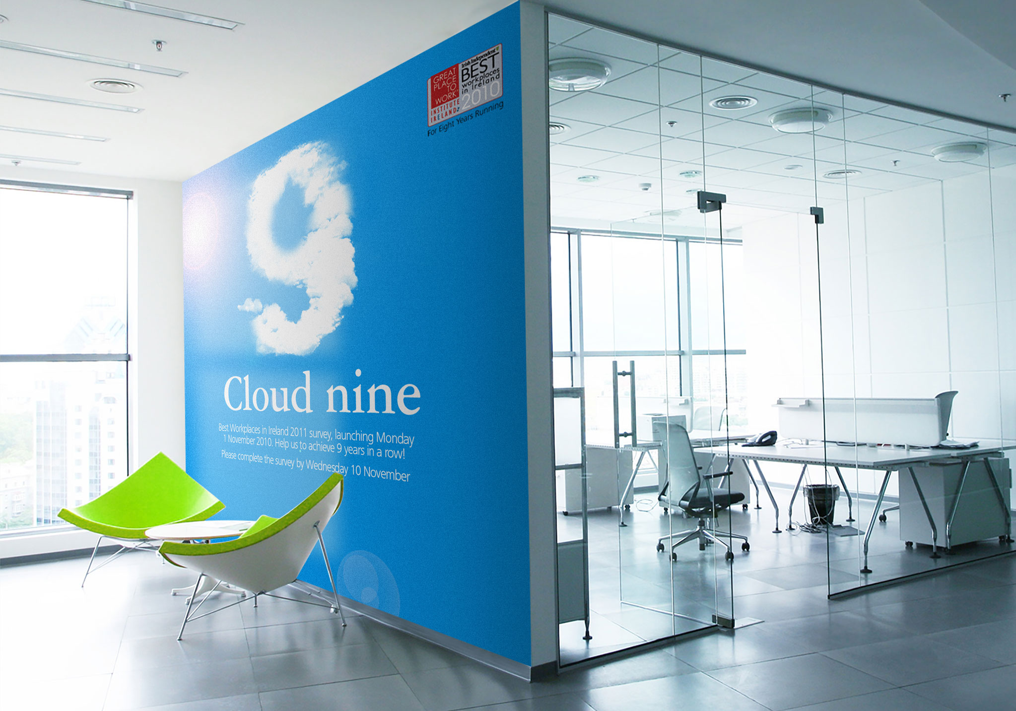 Large wall graphic showing a number nine made up from clouds with green chairs infront