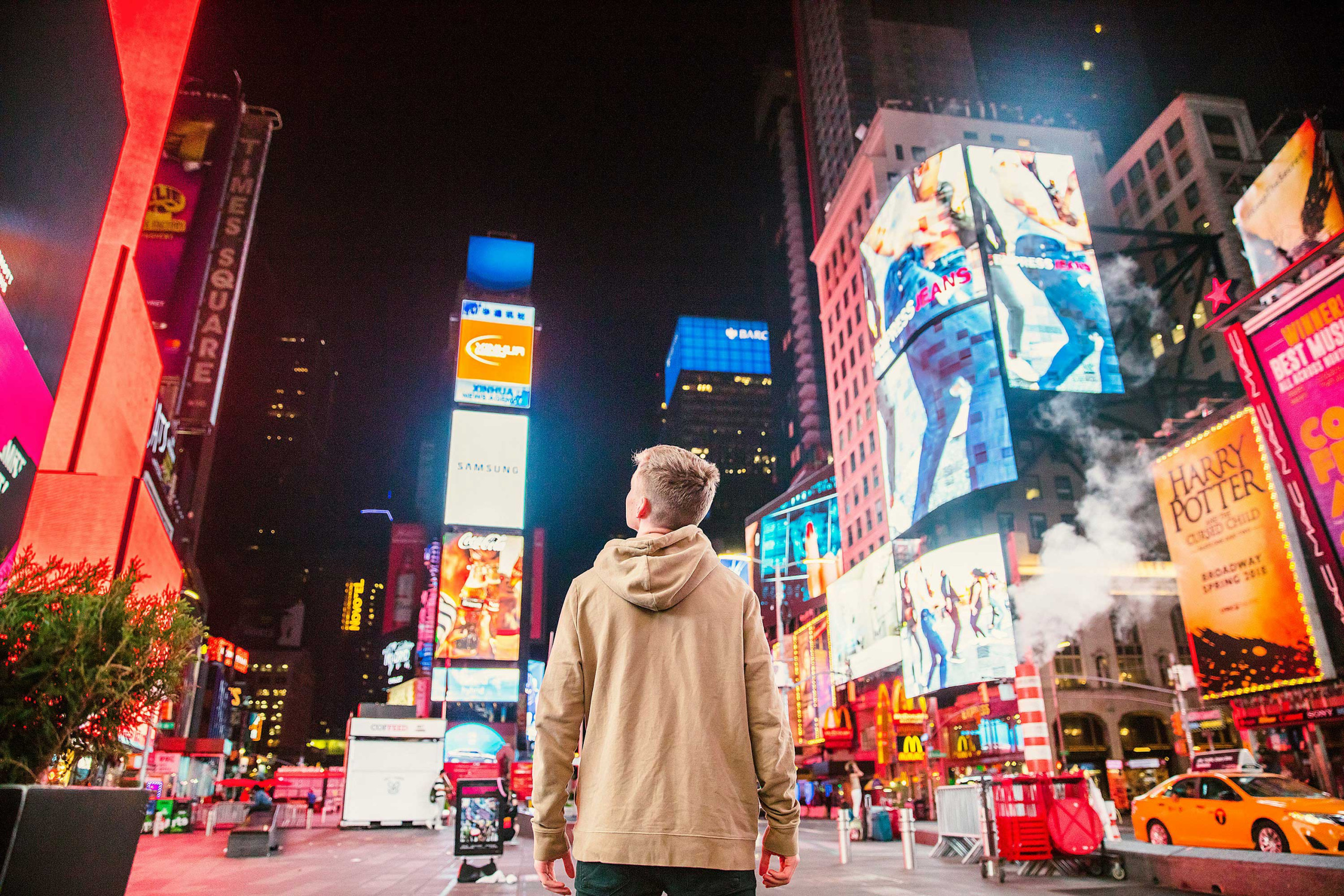 person walking through lots of signage on busy streeet